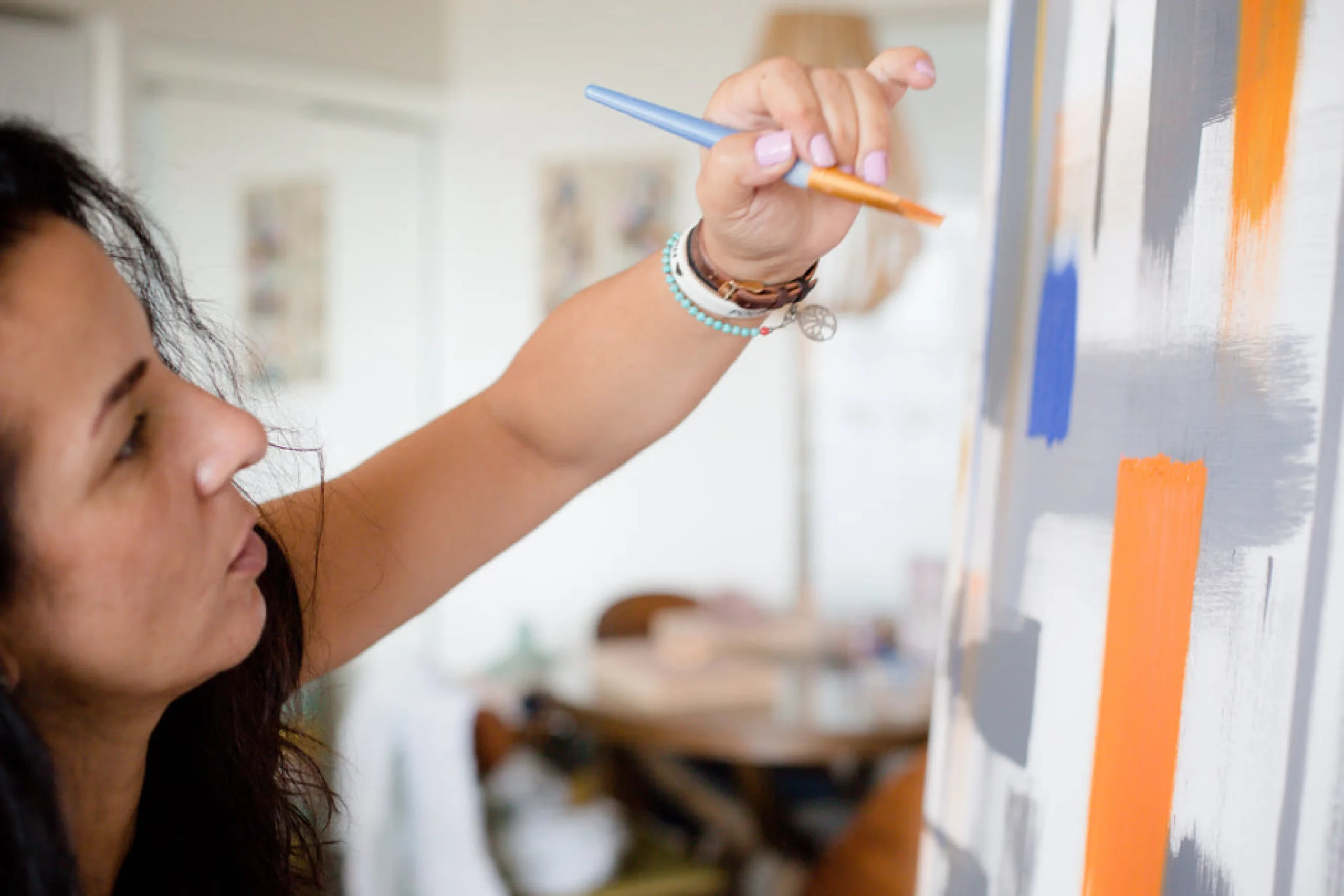 artist-holds-a-paint-brush-up-to-there-canvas