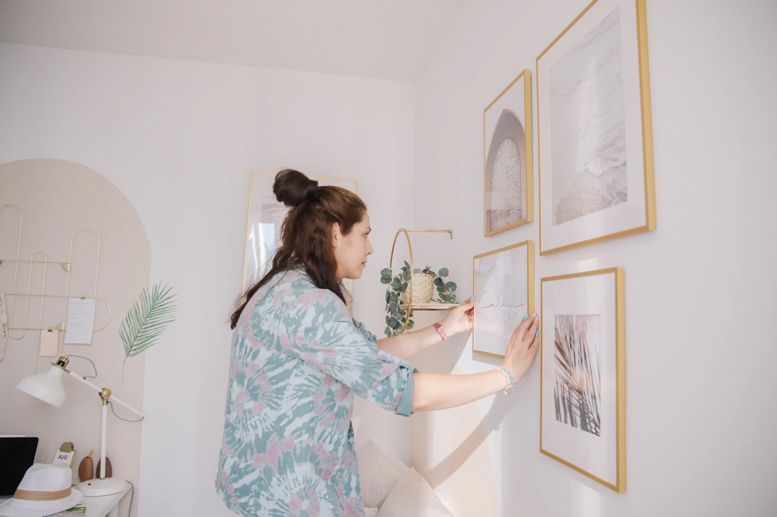 person-hanging-a-wooden-frame-on-a-white-wall