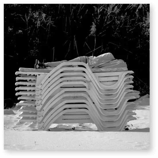 Man sleeping on a deck chair stack
